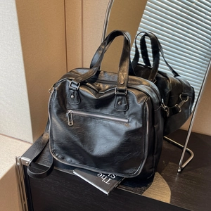 Detailed close-up of large black PU leather satchel bag with stylish zipper accents