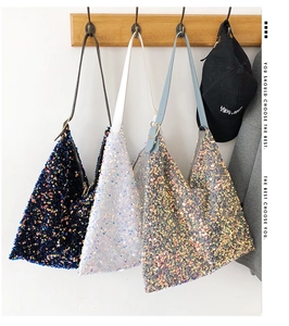 Detailed close-up showing three sequin tote bags in black, white and gold on wooden hooks