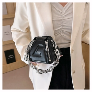Detail of a black geometric PU handbag featuring an oversized silver chunky chain strap