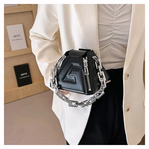Close-up of black geometric PU handbag with 3D embossed letter and silver chain