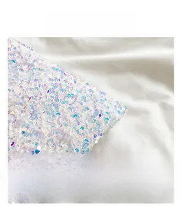 Detailed macro view of white shimmering sequin fabric texture on a large tote bag
