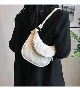 Détail du sac croissant tressé blanc en similicuir avec fermeture éclair dorée élégante