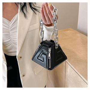 Close-up of black geometric PU handbag with embossed G pattern and silver chain handle