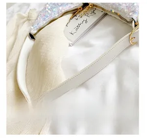 Detail showing high-quality white leather strap with gold hardware and shimmering sequins