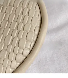 Gros plan sur la texture en cuir PU tressé beige d'un sac à main tendance