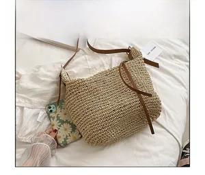 Macro detail of natural straw tote bag with brown PU leather straps and side ties