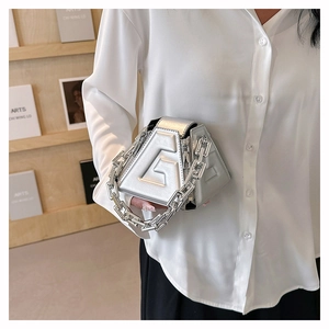 Close-up of a silver geometric PU handbag featuring an embossed G detail and chunky chain