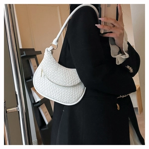 Selfie miroir montrant le sac d'épaule blanc tressé et la texture fine du cuir