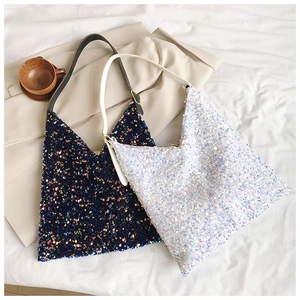Detailed macro view of sparkling sequins on triangular tote bags in blue and white colors