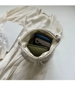 Detailansicht der gewebten Strohtasche mit cremefarbenem Satinfutter und Reißverschluss