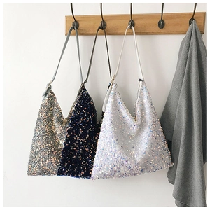 Detailed view of shimmering sequin tote bags in silver, navy blue and pearl white