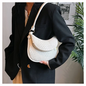 Détail d'un sac à bandoulière blanc en similicuir tressé avec bandoulière et fermeture
