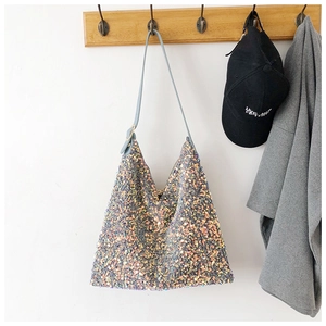 Detailed shot of sparkling sequin tote bag with adjustable strap in home setting