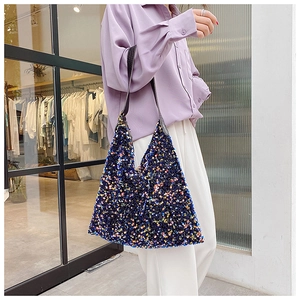 Detailed shot of sparkling sequin texture and leather strap on a blue tote shoulder bag