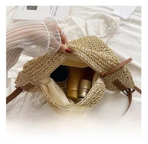 Detail view of the straw tote bag's spacious interior with lining and metal zipper