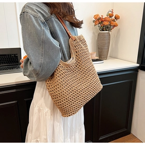 Close-up of woven straw handbag texture featuring brown leather straps and spacious interior
