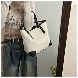 Close-up of contrast large tote bag featuring cream canvas and black corner reinforcements