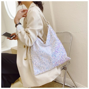 Close-up of a white sequin shoulder bag with leather strap and metallic zipper detail