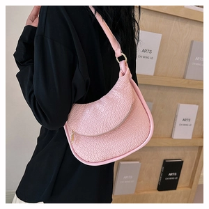 Détail du sac à bandoulière rose en similicuir crocodile avec anneau doré sur un mannequin