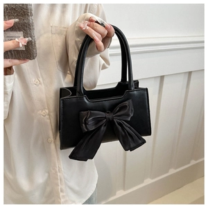 Détail d'un sac à main élégant en PU noir avec un grand nœud en satin décoratif