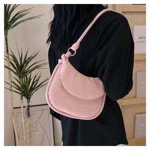 Détail du sac hobo rose avec texture tressée et finitions métalliques dorées chic