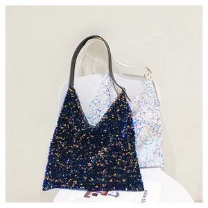 Close-up of glitter sequins shoulder bags in blue and white with leather straps on a white chair