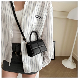 Close-up of black quilted puffer mini bag with fine stitching and top handle