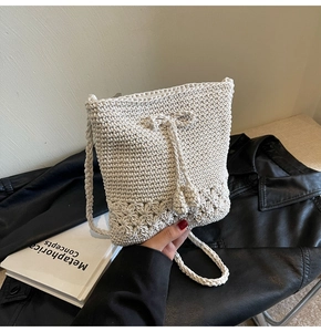 Detail der handgewebten Häkeltasche mit floralen Ausschnitten und Kordelzugquasten