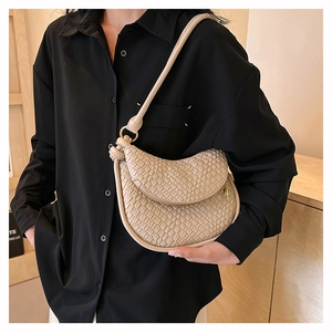 Détail d'un sac à bandoulière beige en cuir PU tressé avec fermeture éclair dorée élégante