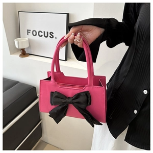 Détail du sac à main en cuir PU rose avec un grand nœud décoratif en soie noire