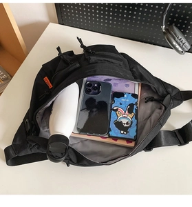 Vue de dessus du sac à bandoulière en nylon ouvert avec grande capacité et compartiments