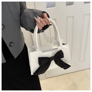 Détail d'un sac à main blanc en cuir PU orné d'un grand nœud en satin noir décoratif
