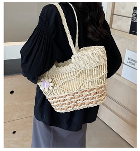 Détail du sac cabas en paille tissé avec fleur 3D violette et bandoulière tressée