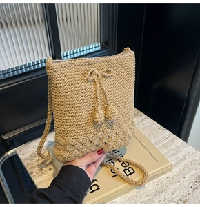 Detailansicht der Strohtasche mit gewebter Textur, Zier Schleife und weichen Pompons