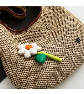 Detail of hand-woven beige tote bag featuring 3D floral decoration and handmade label