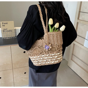 Détail du sac cabas en paille tissé à la main avec bord festonné et charm papillon violet