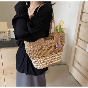 Détail du sac cabas en paille fait main avec pendentif papillon en crochet et fleurs