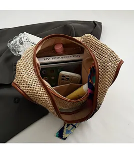 Detail view of beige woven straw tote interior with large capacity and zipped pocket