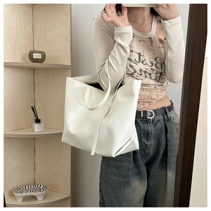 Borsa tote minimalista in pelle sintetica bianca indossata a spalla da donna