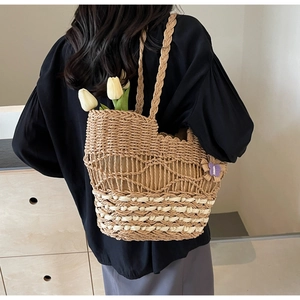 Détail du sac à main en paille tressée avec papillon en tricot violet et motif ajouré