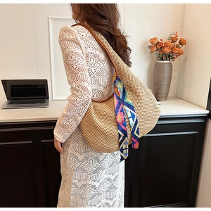 Detail of straw woven tote with leather strap and colorful silk scarf accessory