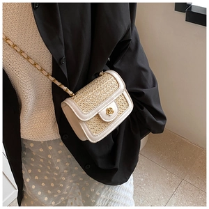Dettaglio della borsa in paglia intrecciata e pelle PU bianca con fibbia a camelia oro
