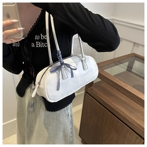 Detail of white PU leather cylinder bag with blue checkered bow and slim shoulder strap