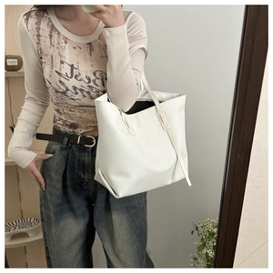 Dettaglio della borsa tote minimalista in ecopelle bianca con trama fine e spalline sottili