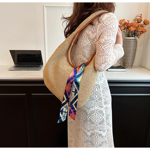 Detail of woven straw hobo bag with printed silk scarf and premium leather strap