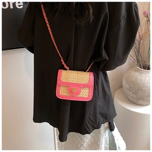 Dettaglio del bordo in pelle rosa e borsa a tracolla in paglia con chiusura a fiore oro