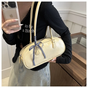 Detail of beige cylinder shoulder bag in premium PU leather with checkered bow tie
