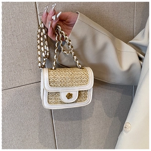 Dettaglio borsa a tracolla in paglia intrecciata beige con chiusura a fiore dorata