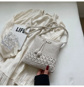 Detail der handgehäkelten Tasche in Creme mit hohlgearbeitetem Sonnenblumenmuster und Baumwolle