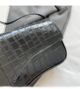 Detail showing the glossy black crocodile pattern texture and premium PU leather finish